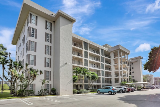 view of building exterior with uncovered parking