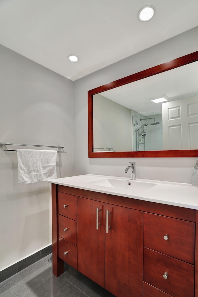 bathroom with vanity, baseboards, a shower stall, and recessed lighting