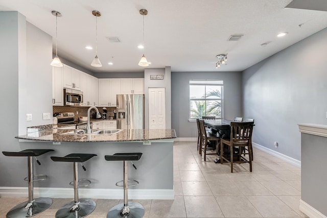 75 Atlantic Grove Way, Delray Beach, FL 33444 - kitchen with appliances with stainless steel finishes, a sink, a peninsula, dark stone counters, and recessed lighting