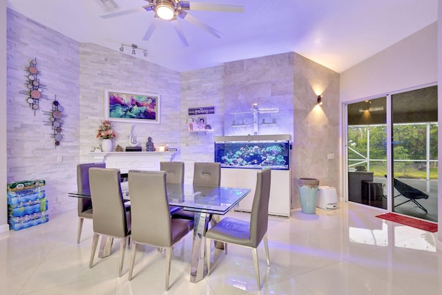 tiled dining space featuring lofted ceiling and a ceiling fan