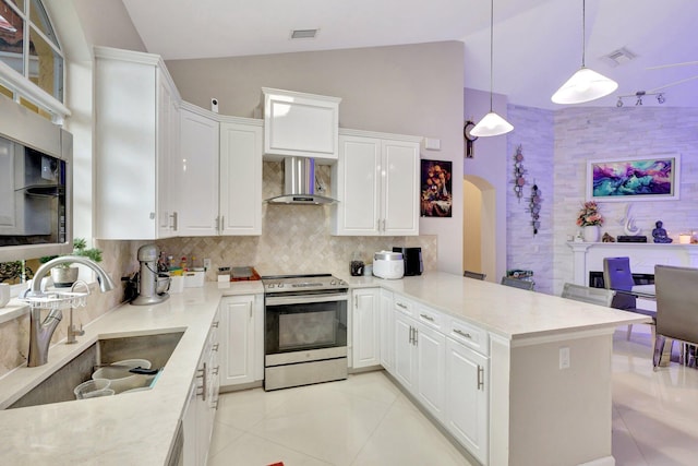 kitchen with lofted ceiling, visible vents, a sink, wall chimney exhaust hood, and electric range