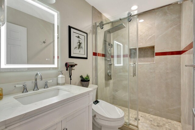 full bath featuring a stall shower, vanity, and toilet