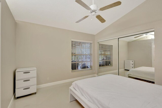 bedroom featuring a closet, vaulted ceiling, baseboards, and a ceiling fan