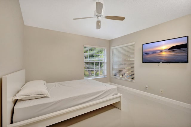 bedroom with ceiling fan and baseboards