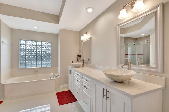 full bath featuring double vanity, a shower stall, a garden tub, and a sink