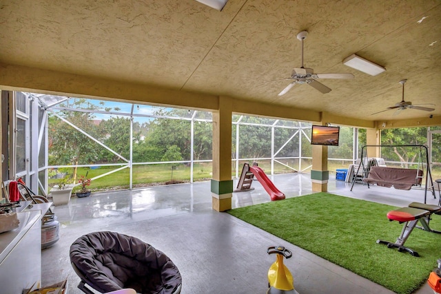 sunroom / solarium featuring a ceiling fan