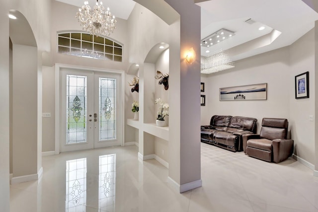 tiled entrance foyer with french doors, baseboards, recessed lighting, arched walkways, and a notable chandelier