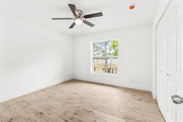 unfurnished bedroom featuring baseboards, ceiling fan, a closet, and light wood finished floors