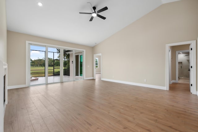 unfurnished living room with light wood-style floors, baseboards, ceiling fan, and high vaulted ceiling