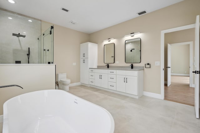 full bath with double vanity, visible vents, an enclosed shower, a freestanding tub, and recessed lighting