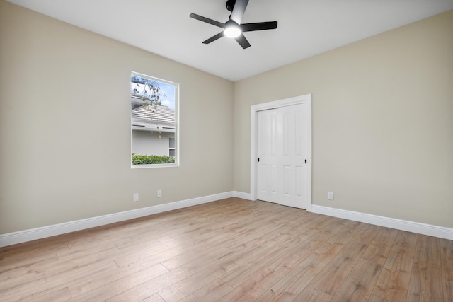 spare room with ceiling fan, baseboards, and light wood finished floors
