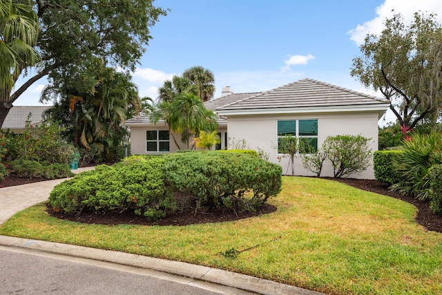 10206 Isle Of Pines Ct, Port Saint Lucie, FL 34986 - view of front of home with stucco siding, a front lawn, a chimney, and a tile roof