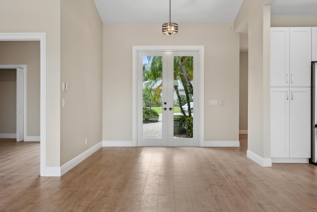 doorway to outside with baseboards, french doors, and light wood finished floors