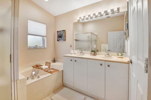 bathroom featuring a stall shower, a bath, double vanity, and tile patterned flooring