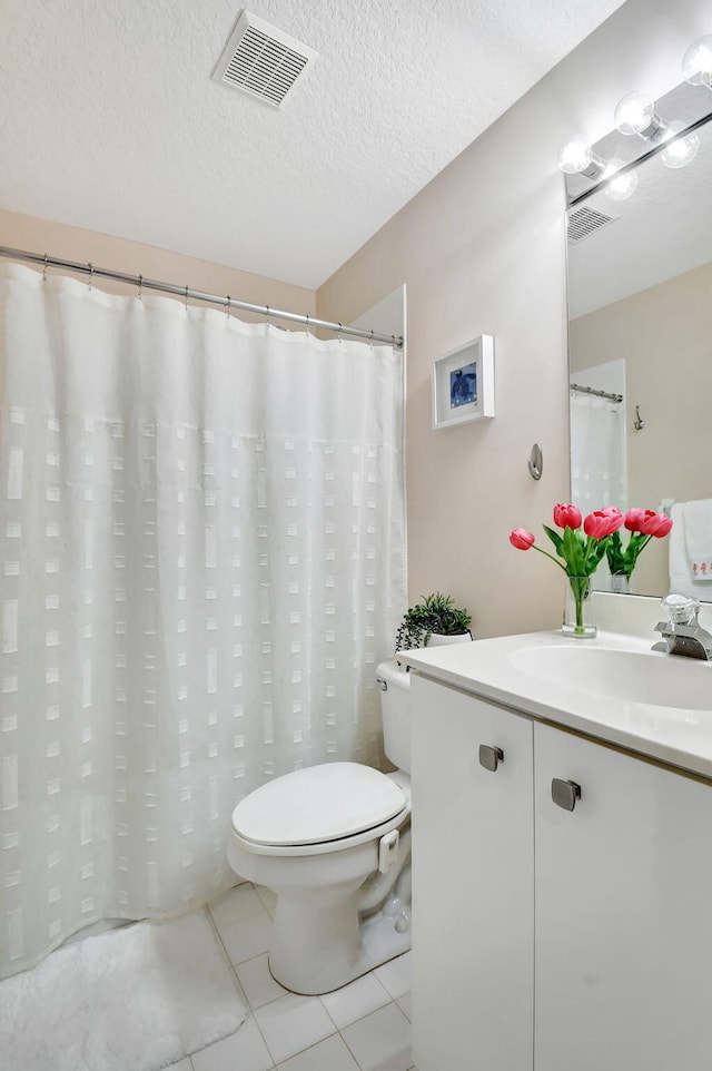 bathroom featuring toilet, tile patterned flooring, vanity, and a textured ceiling