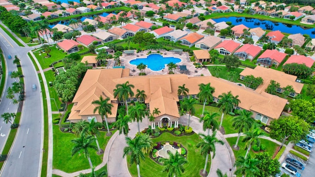 aerial perspective of suburban area featuring a pool area and a large body of water