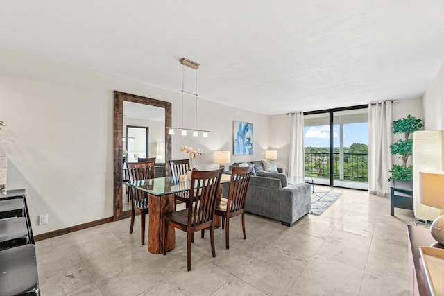 dining area featuring baseboards and a wall of windows
