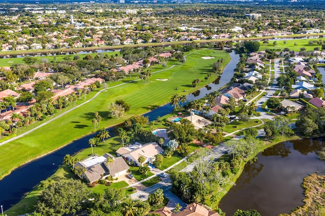 drone / aerial view with a water view, golf course view, and a residential view