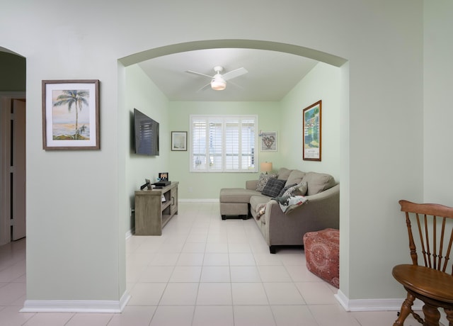 520 NW Galatone Ct, Port Saint Lucie, FL 34986 - living room with baseboards, arched walkways, a ceiling fan, and light tile patterned floors
