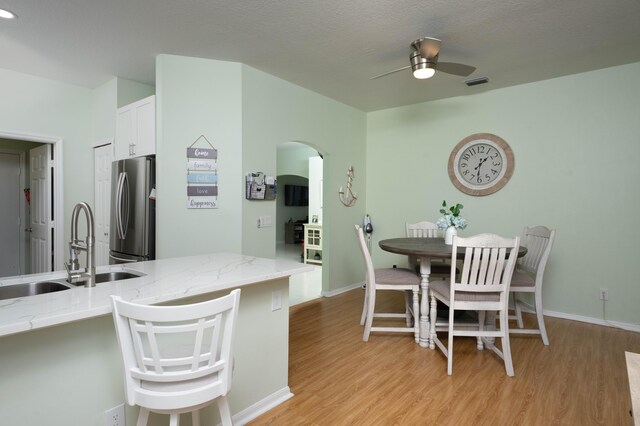 520 NW Galatone Ct, Port Saint Lucie, FL 34986 - kitchen featuring visible vents, freestanding refrigerator, a ceiling fan, a sink, and light wood-style flooring