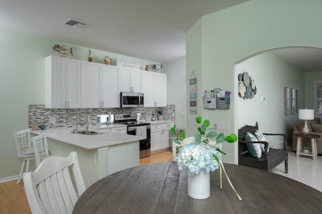 520 NW Galatone Ct, Port Saint Lucie, FL 34986 - kitchen with a sink, arched walkways, stainless steel appliances, backsplash, and visible vents