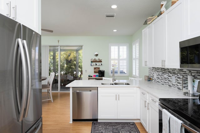 520 NW Galatone Ct, Port Saint Lucie, FL 34986 - kitchen featuring plenty of natural light, a sink, white cabinets, and stainless steel appliances