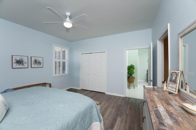 520 NW Galatone Ct, Port Saint Lucie, FL 34986 - bedroom featuring a closet, baseboards, ceiling fan, dark wood-type flooring, and a textured ceiling