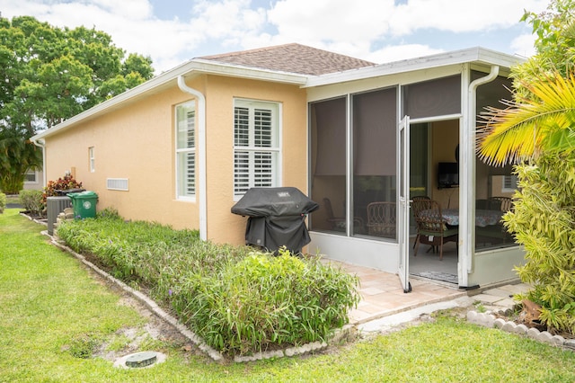 520 NW Galatone Ct, Port Saint Lucie, FL 34986 - back of house with roof with shingles, a yard, stucco siding, and a sunroom