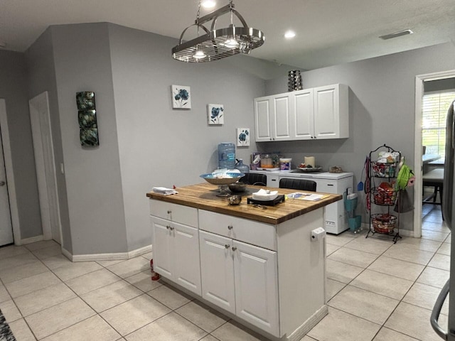 7746 99th Ct, Vero Beach, FL 32967 - kitchen featuring baseboards, butcher block counters, light tile patterned floors, and white cabinets