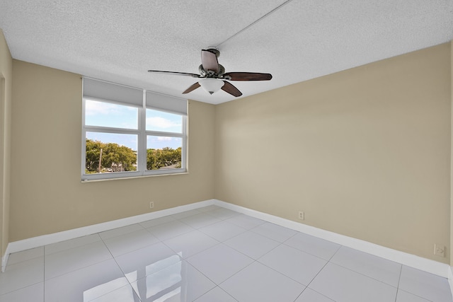 unfurnished room with baseboards, a textured ceiling, ceiling fan, and light tile patterned floors
