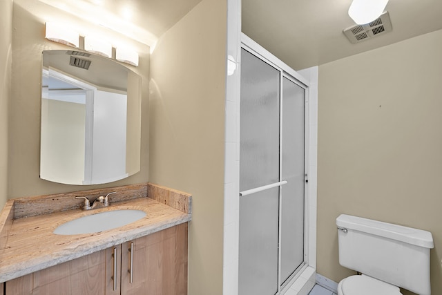 full bath featuring vanity, a stall shower, toilet, and visible vents