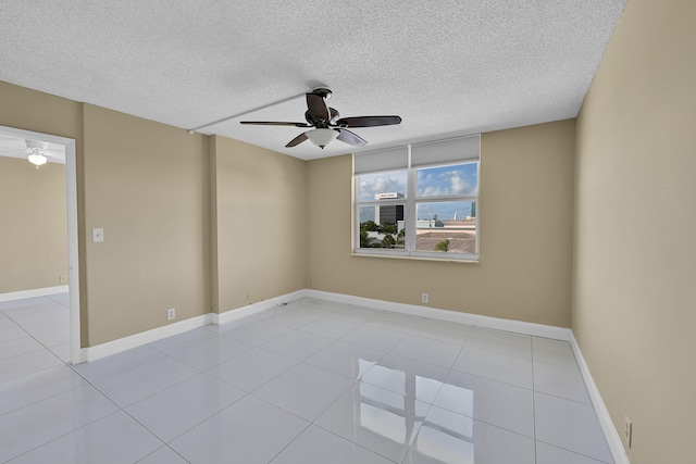 tiled spare room featuring baseboards, ceiling fan, and a textured ceiling