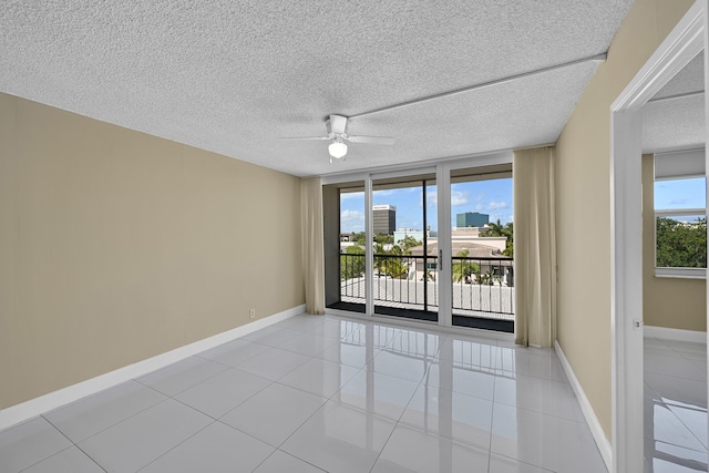 unfurnished room with baseboards, a ceiling fan, and light tile patterned floors