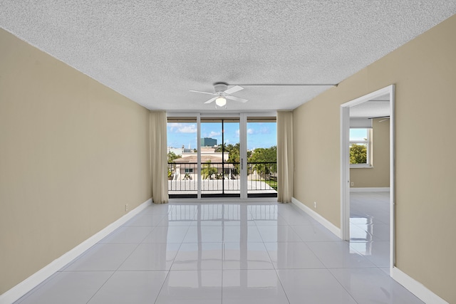 unfurnished room featuring light tile patterned floors, baseboards, ceiling fan, and a textured ceiling