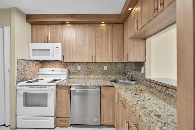 kitchen featuring decorative backsplash, light brown cabinetry, white appliances, light stone counters, and a sink