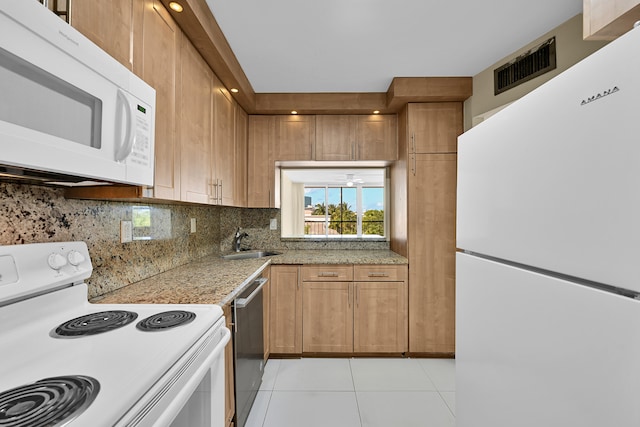 kitchen with a sink, white appliances, light tile patterned floors, tasteful backsplash, and visible vents