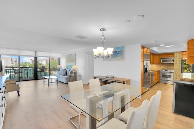 dining room with recessed lighting, visible vents, light wood-type flooring, and a notable chandelier
