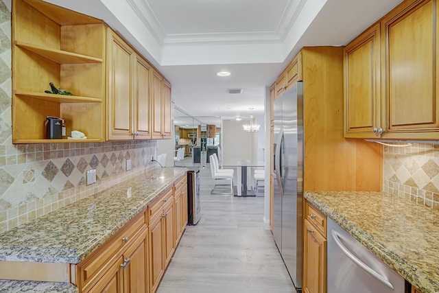 kitchen with appliances with stainless steel finishes, ornamental molding, light wood finished floors, and tasteful backsplash