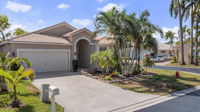 10867 Jefferson Way, Boynton Beach, FL 33437 - mediterranean / spanish home featuring an attached garage, stucco siding, concrete driveway, and a tile roof
