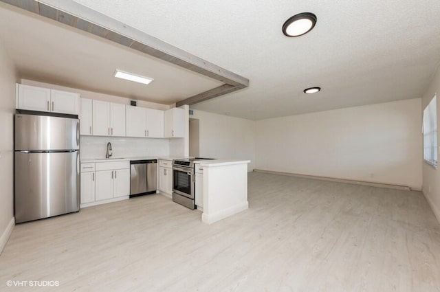 kitchen featuring a sink, stainless steel appliances, light countertops, white cabinets, and light wood-style floors