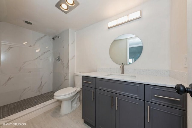 full bathroom with toilet, a marble finish shower, and vanity