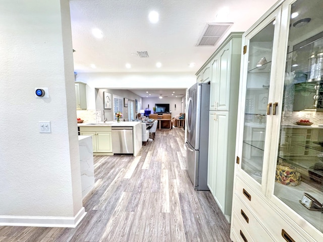 380 Laurie Rd, West Palm Beach, FL 33405 - kitchen with stainless steel appliances, open floor plan, light wood finished floors, a peninsula, and light countertops