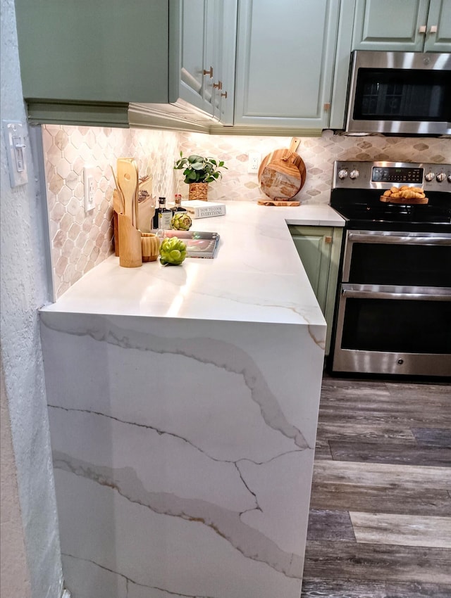 380 Laurie Rd, West Palm Beach, FL 33405 - kitchen with appliances with stainless steel finishes, tasteful backsplash, dark wood-style floors, and light stone counters
