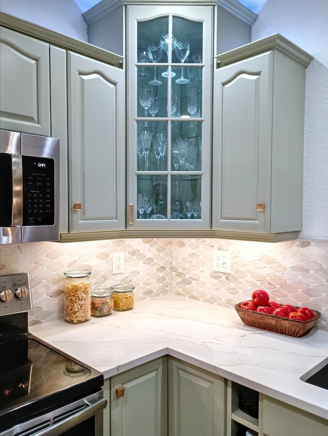 380 Laurie Rd, West Palm Beach, FL 33405 - kitchen with stainless steel appliances, decorative backsplash, glass insert cabinets, and light stone counters