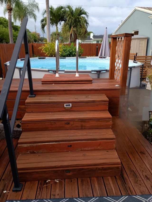 wooden terrace with a fenced in pool and a fenced backyard