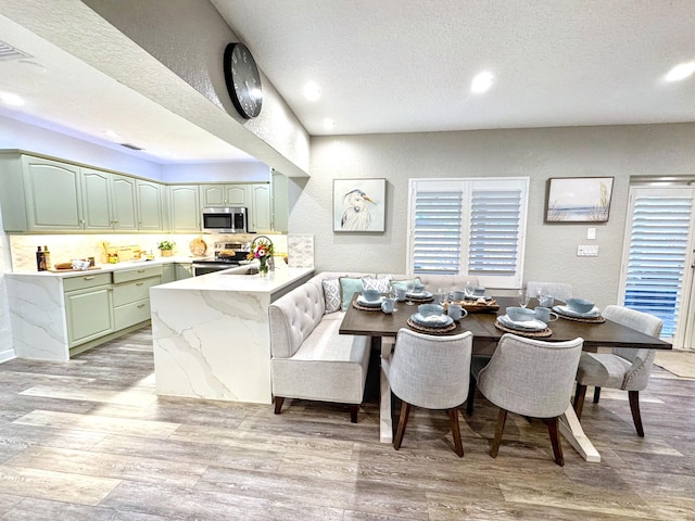 380 Laurie Rd, West Palm Beach, FL 33405 - dining area featuring a textured wall, light wood finished floors, recessed lighting, and a textured ceiling