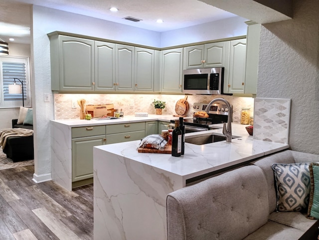 380 Laurie Rd, West Palm Beach, FL 33405 - kitchen with appliances with stainless steel finishes, a sink, a peninsula, tasteful backsplash, and a textured wall