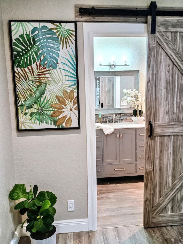 380 Laurie Rd, West Palm Beach, FL 33405 - bathroom with a textured wall, wood finished floors, vanity, and baseboards