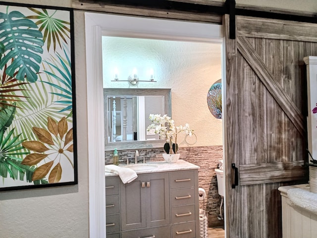 380 Laurie Rd, West Palm Beach, FL 33405 - bathroom featuring vanity, a textured wall, toilet, and wood finished floors