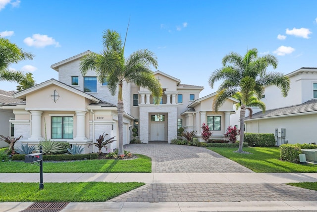 6950 NW 25th Way, Boca Raton, FL 33496 - mediterranean / spanish-style home with decorative driveway, stucco siding, a front yard, and an attached garage